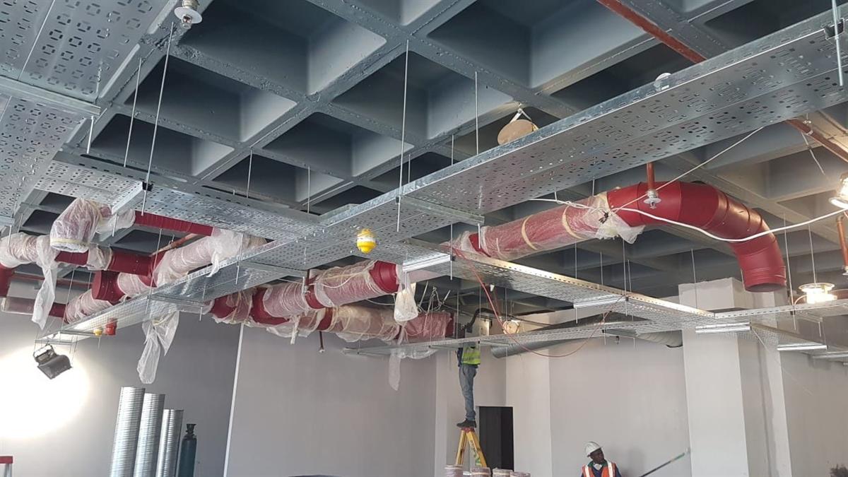 Fire-rated ducting and cable tray coordinated in a commercial ceiling void