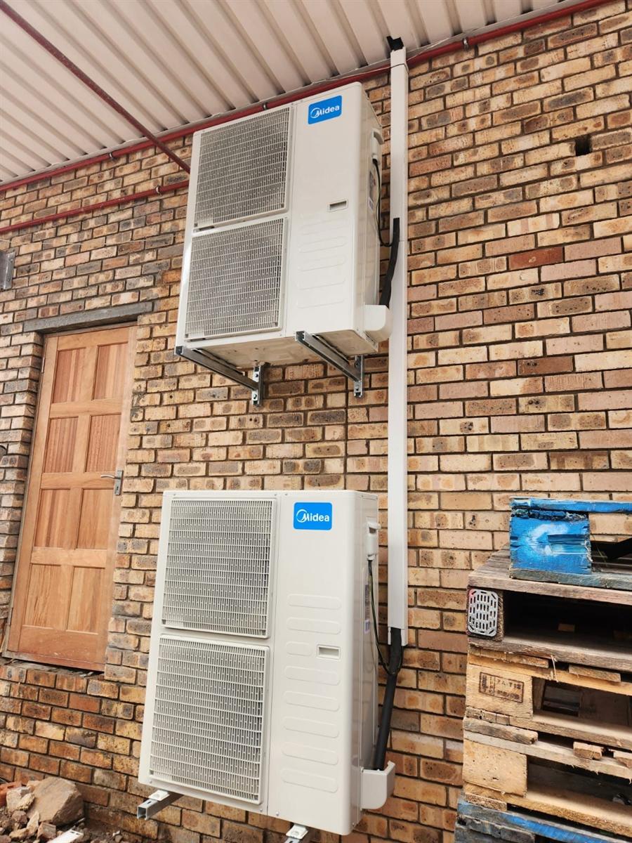 Midea outdoor units wall mounted on brackets with tidy trunking