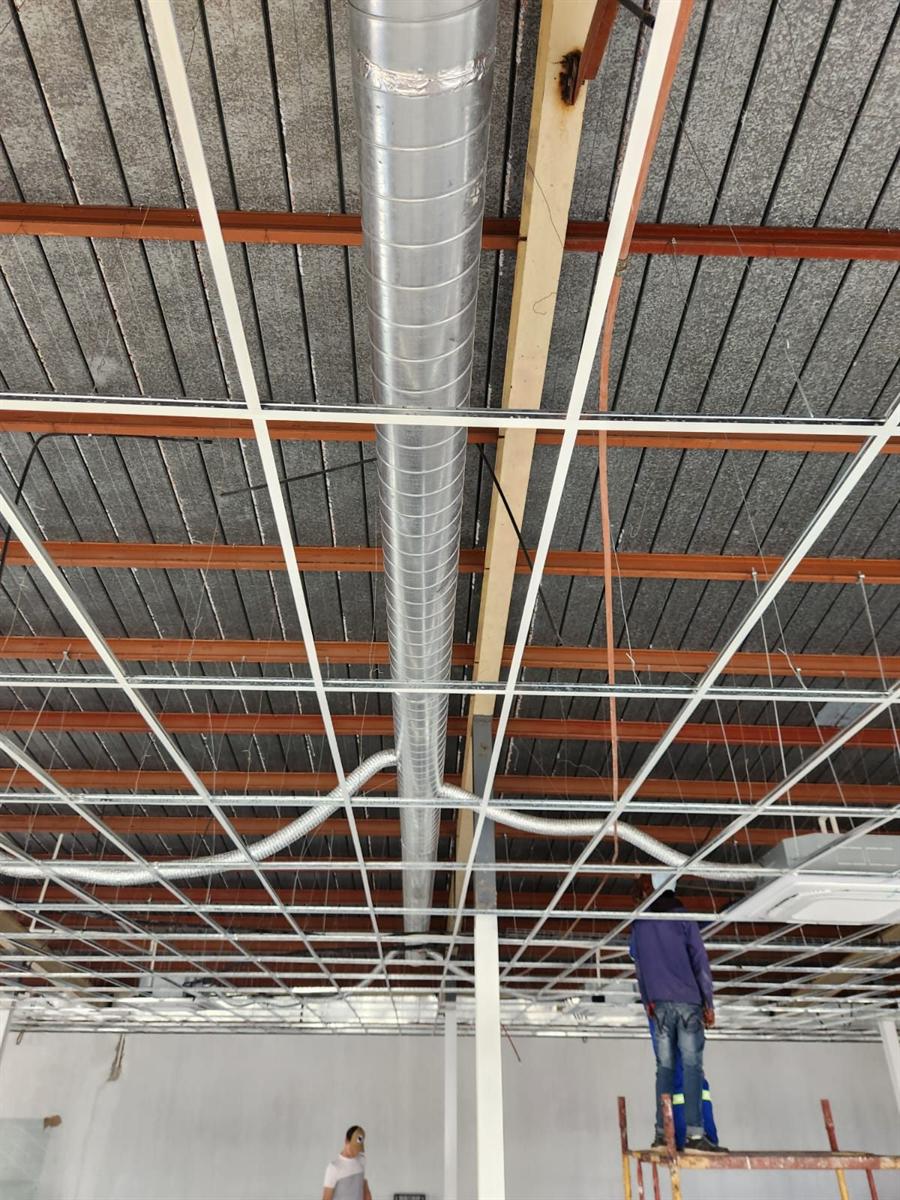 Seasons Find Airconditioning team installing a spiral duct riser in a warehouse